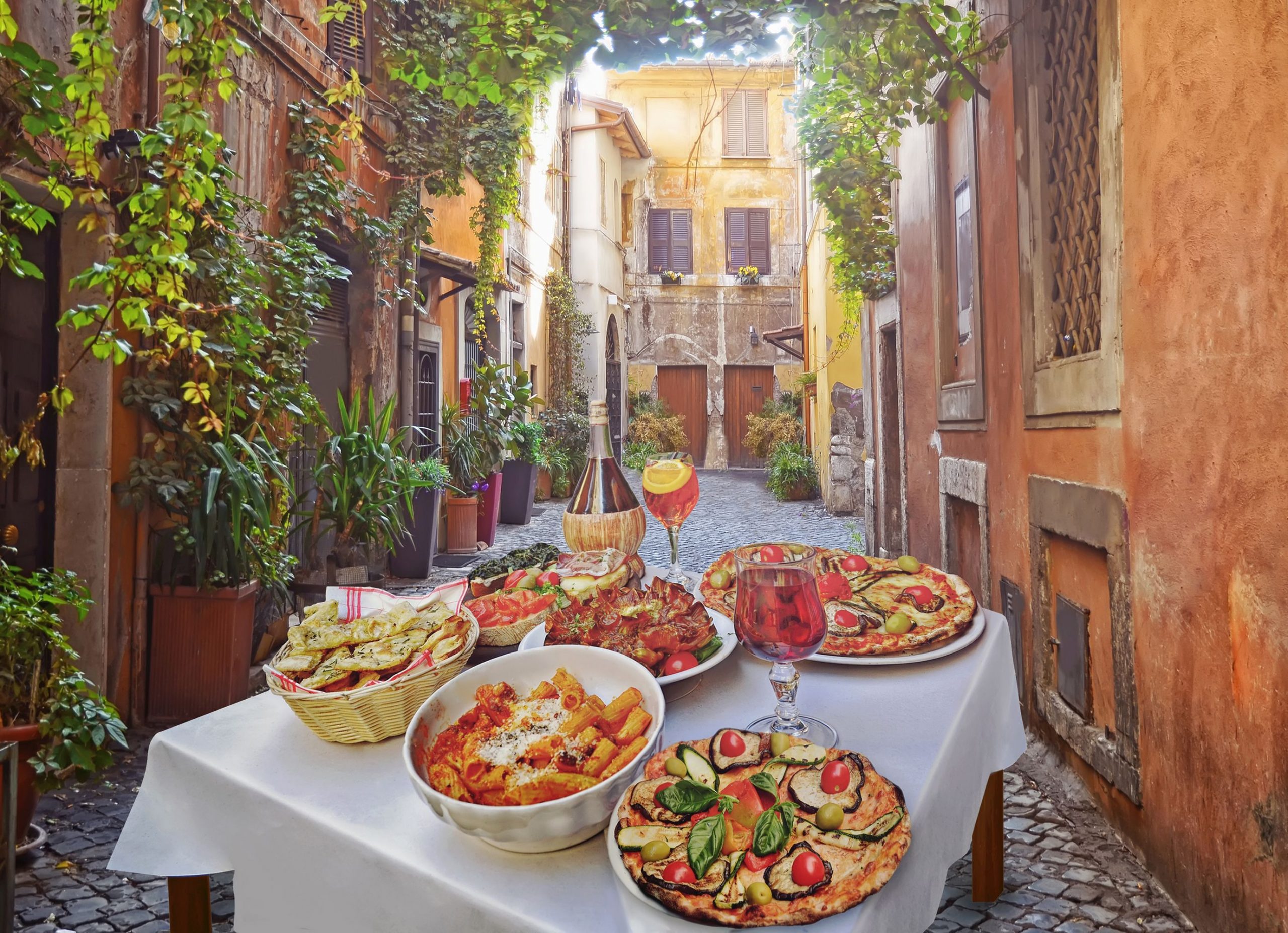 A summer dinner .Pasta , pizza and homemade food arrangement in a restaurant Rome .Tasty and authentic Italian food.